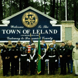 Town officials in front of Town sign
