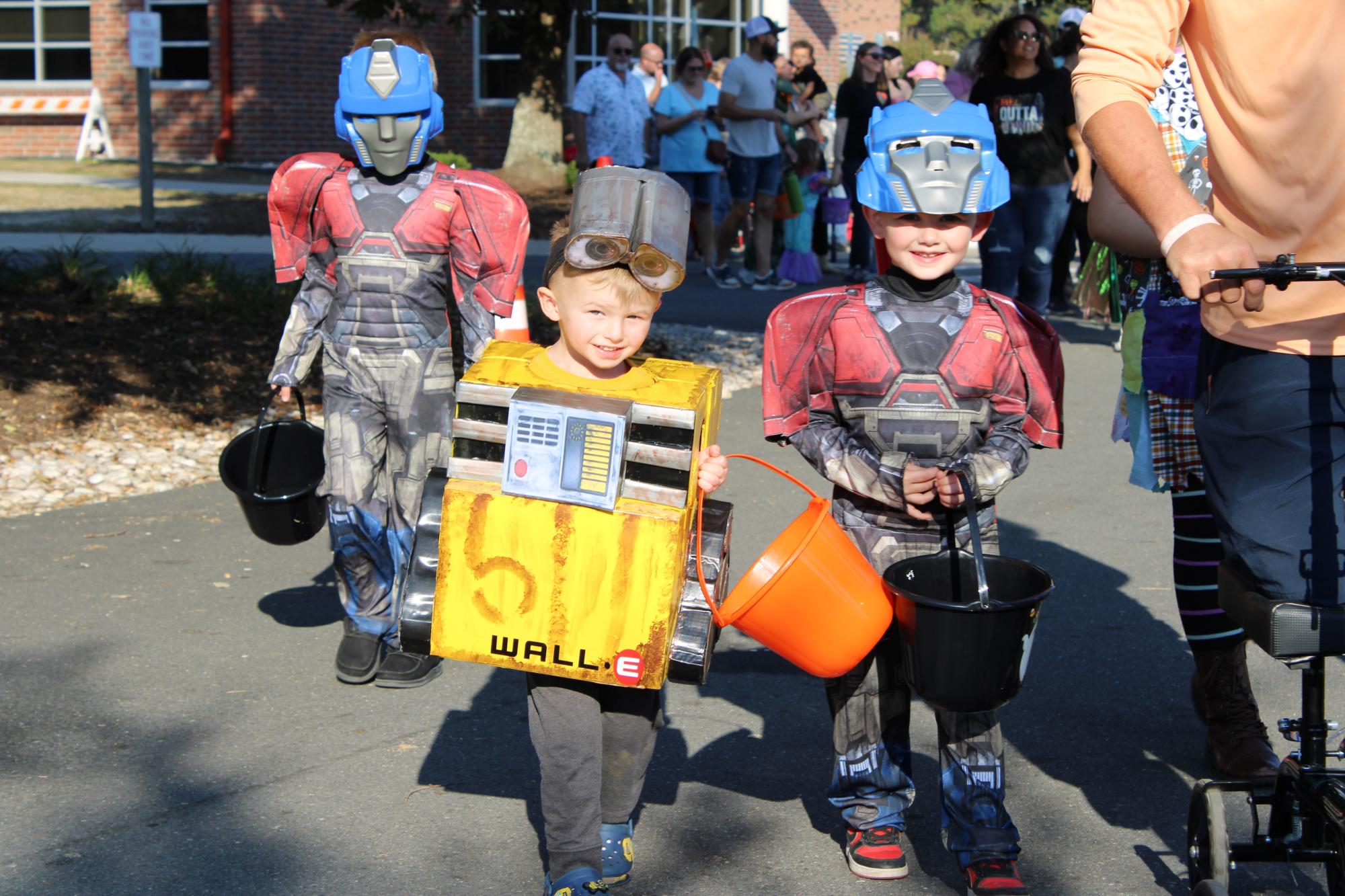 three children dressed up in costumes: transformer, wall-e, and a transformer