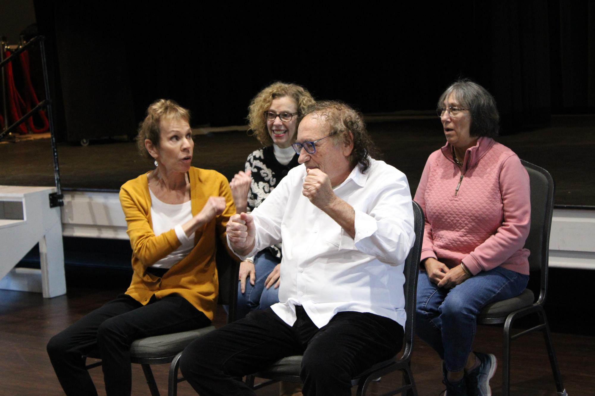 4 people sitting and performing improv