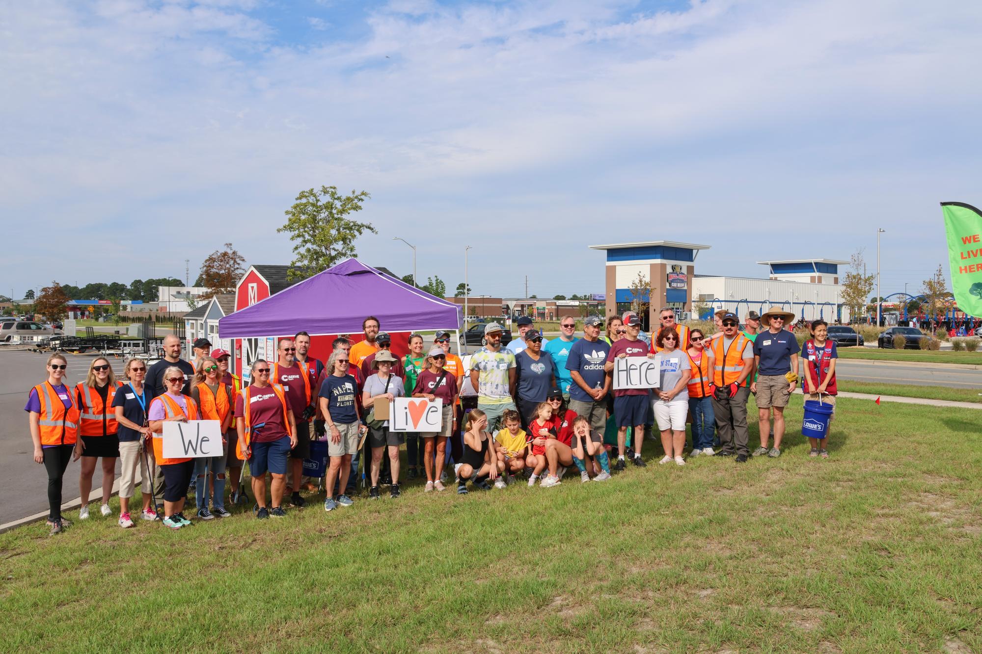 group with We Live Here signs