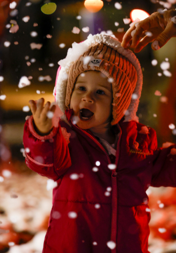 Kid in red puffer playing in snow
