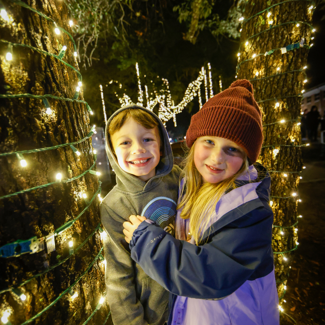 two kid in front of a tree
